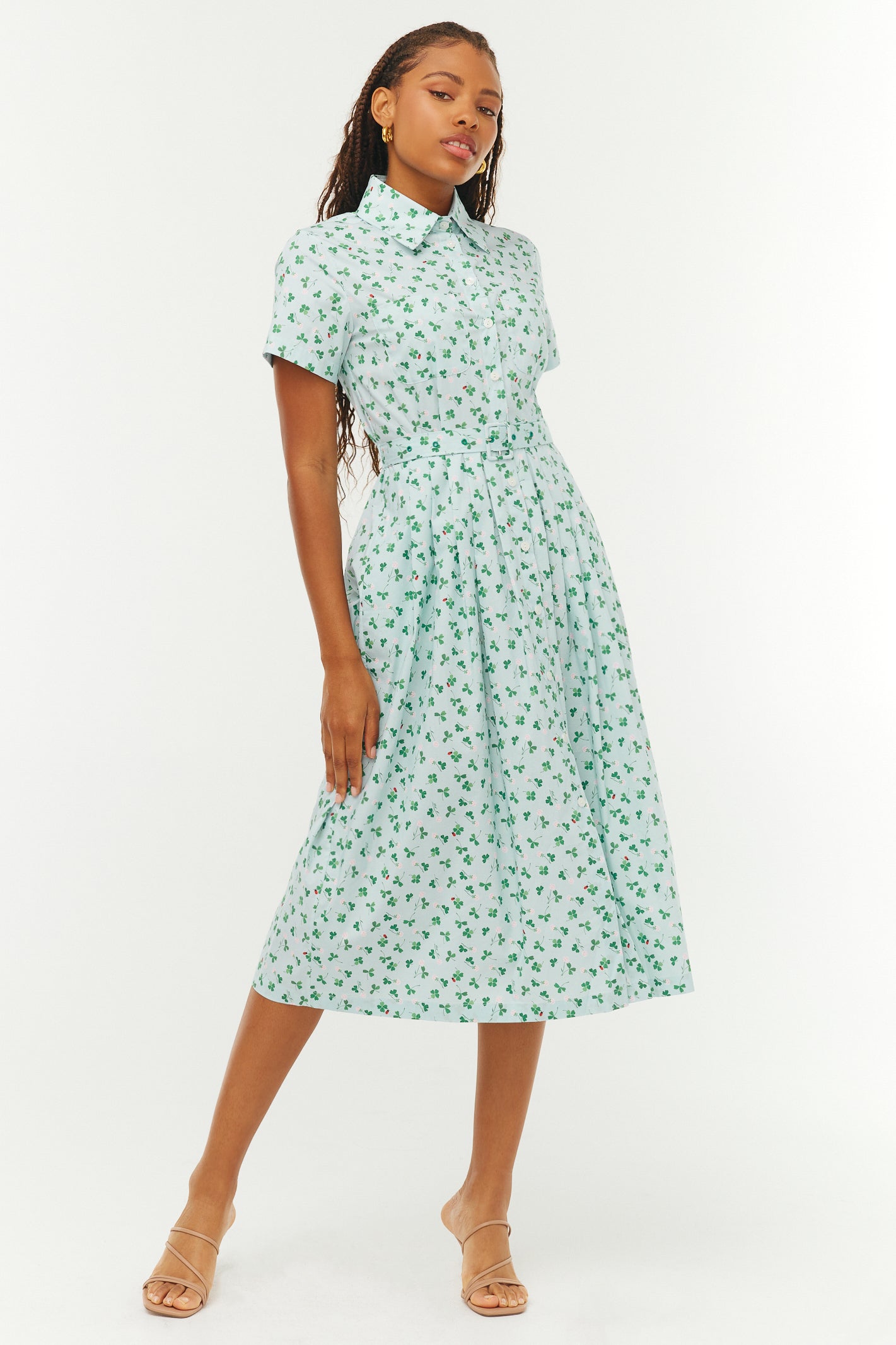 Woman wearing a green and blue floral dress on a white background