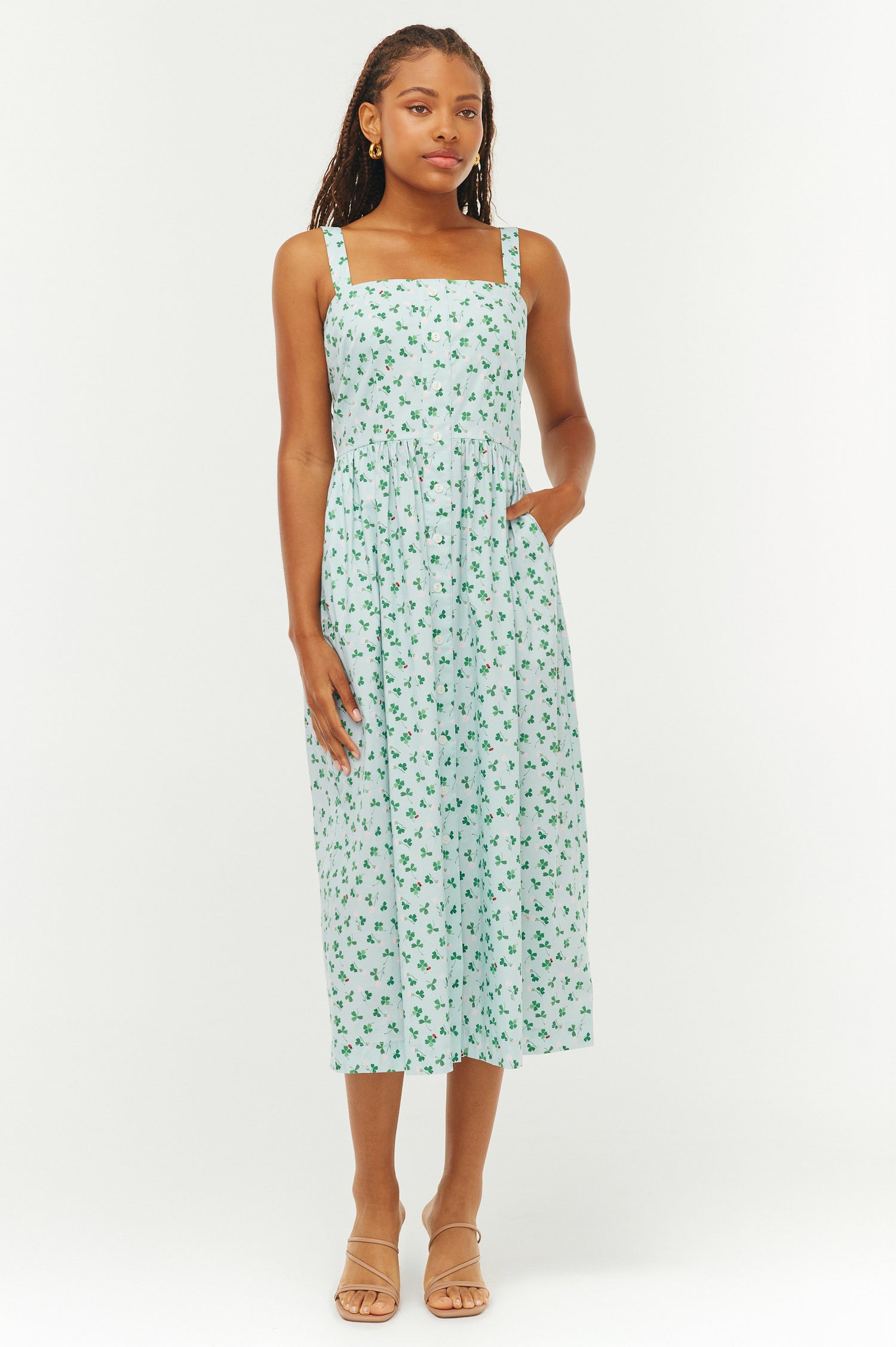 Woman wearing a light green floral dress on a white background