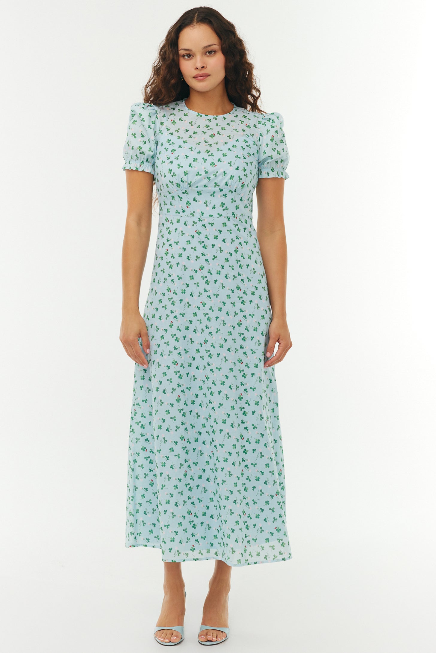 Woman wearing a light blue floral dress on a white background