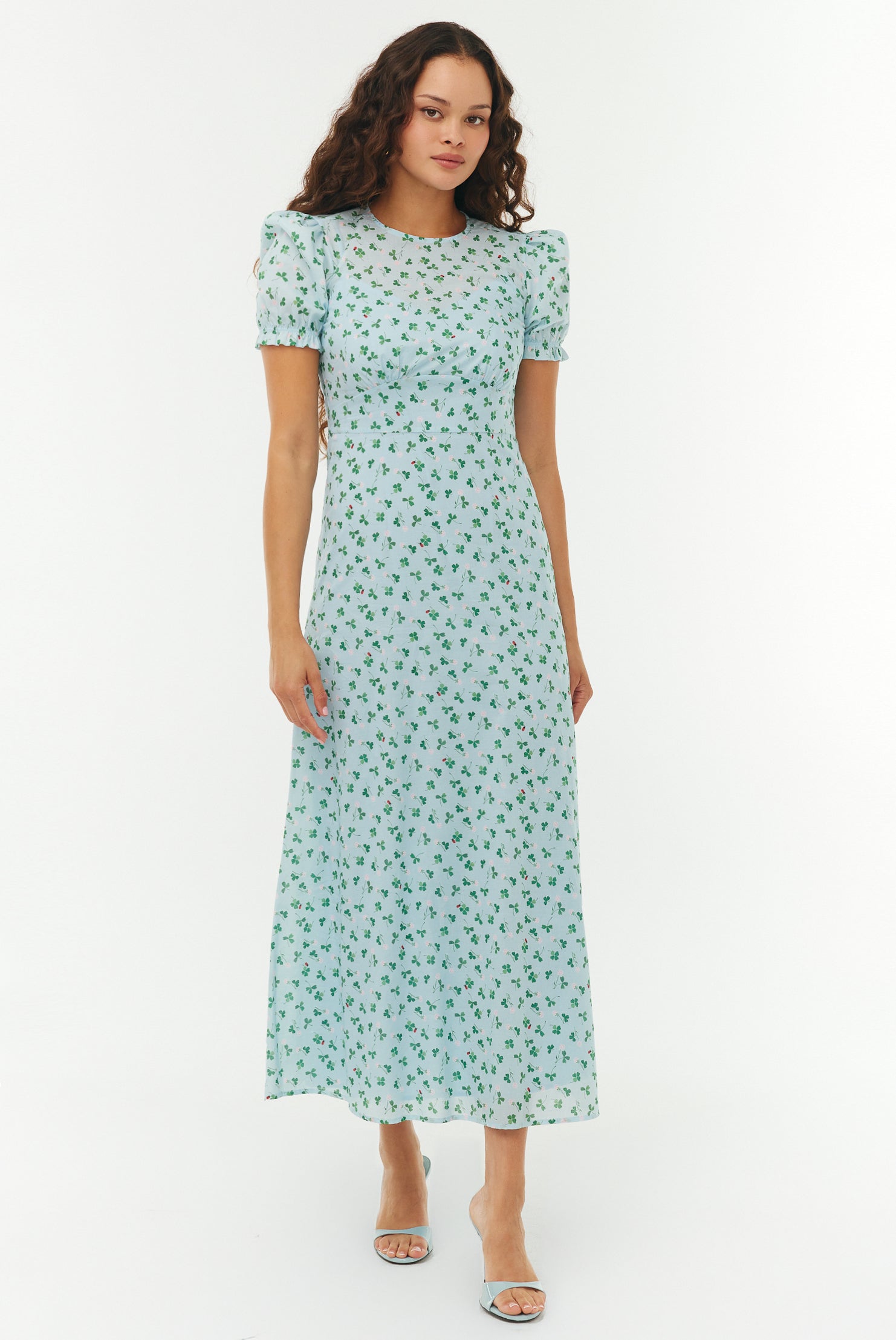 Woman wearing a light blue floral dress on a white background