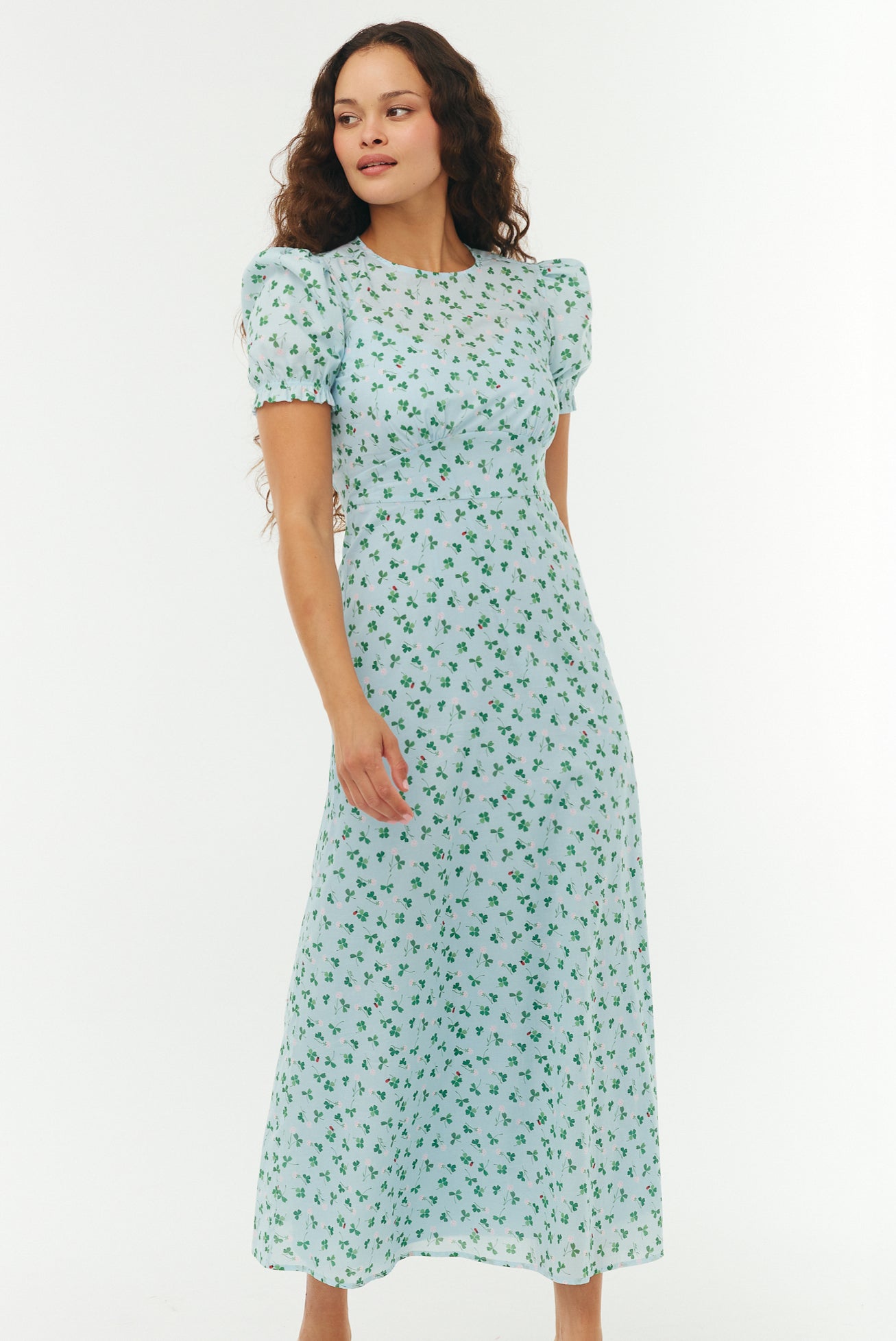 Woman wearing a light blue floral dress on a white background