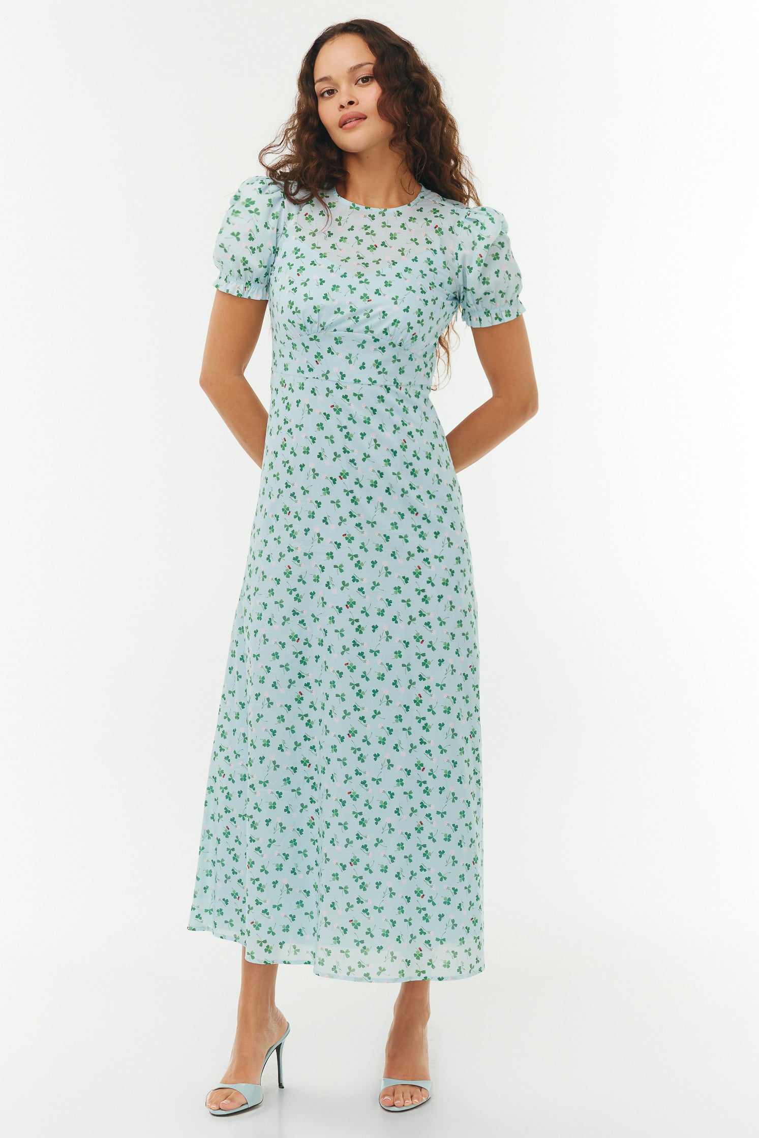 Woman wearing a light blue floral dress on a white background