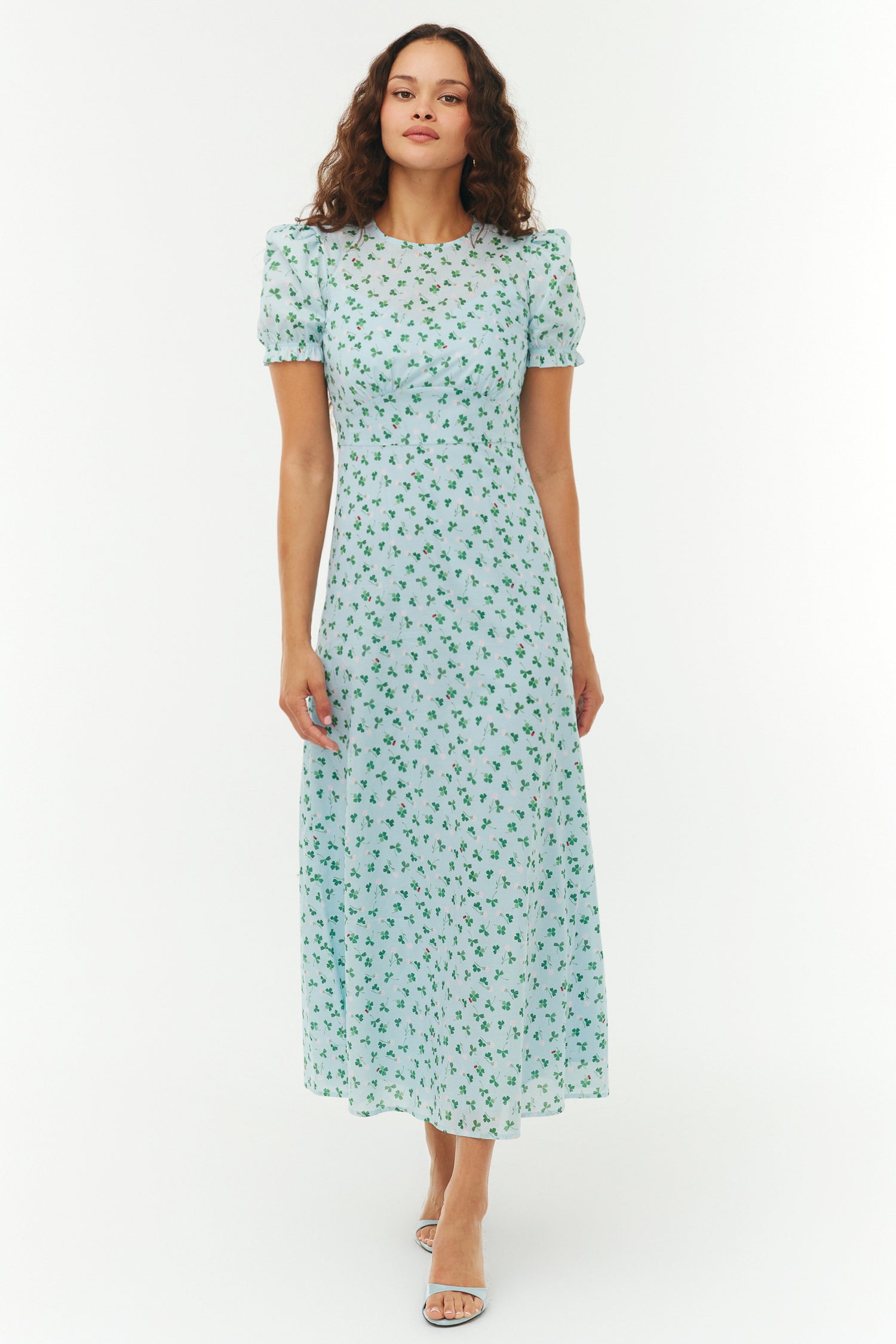 Woman wearing a light blue floral dress on a white background