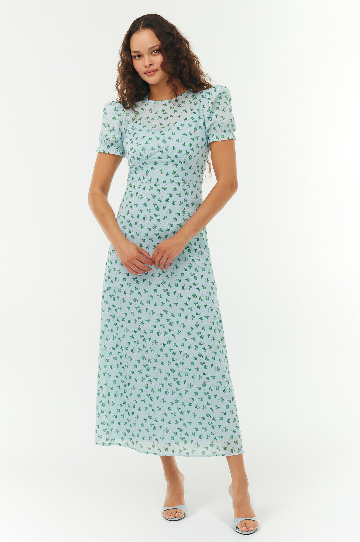 Woman wearing a light blue floral dress on a white background