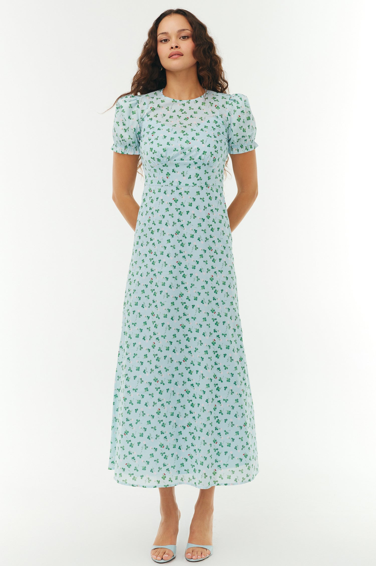 Woman wearing a light blue floral dress on a white background