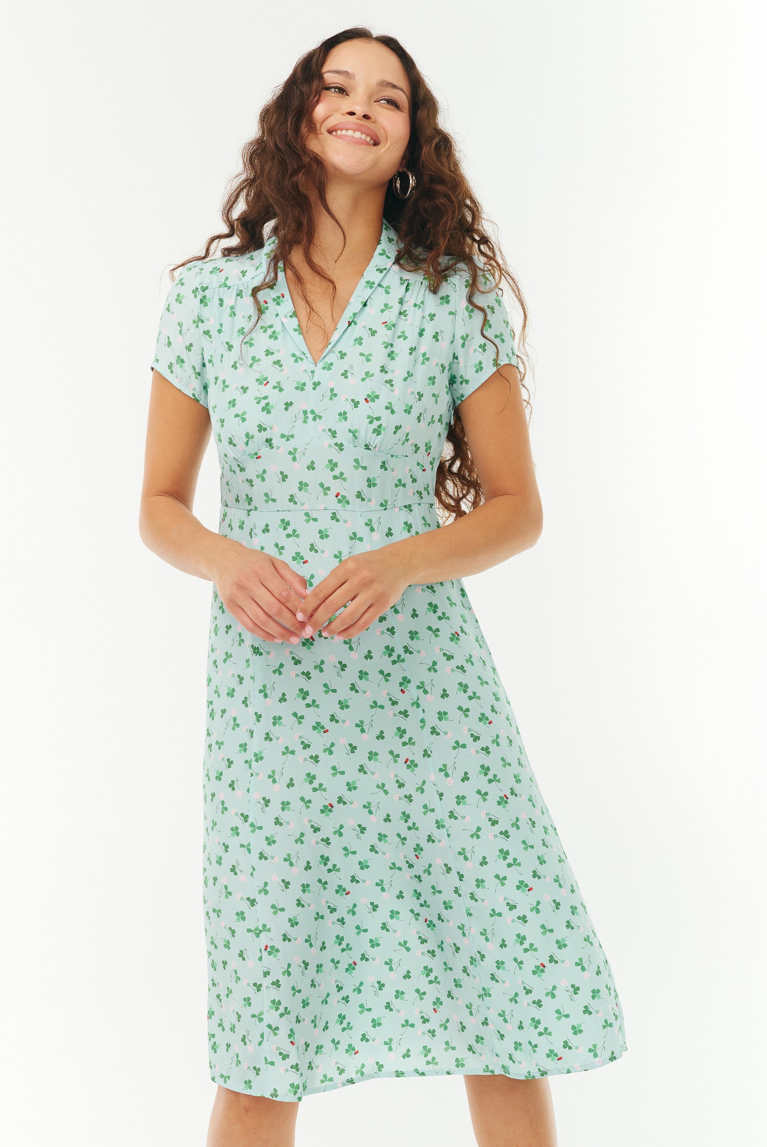 Woman wearing a blue and green floral dress on a white background