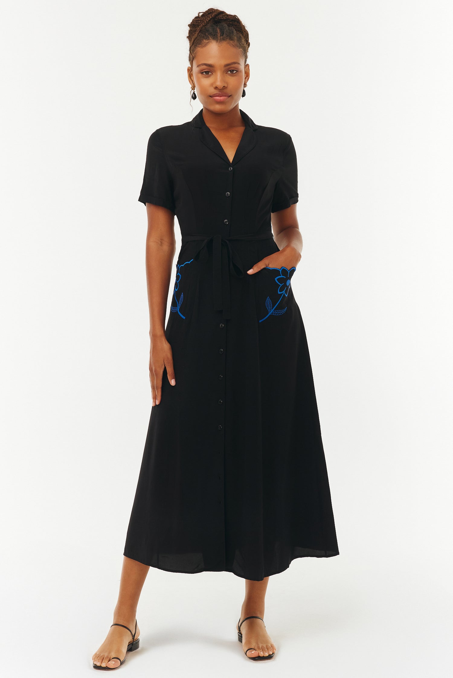 Woman wearing a black dress with blue accents on a white background