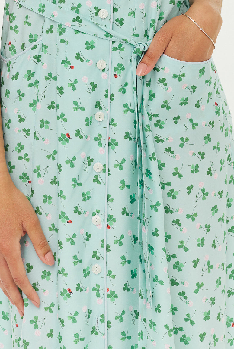 A fabric shot of a light blue and green floral fabric with a belt