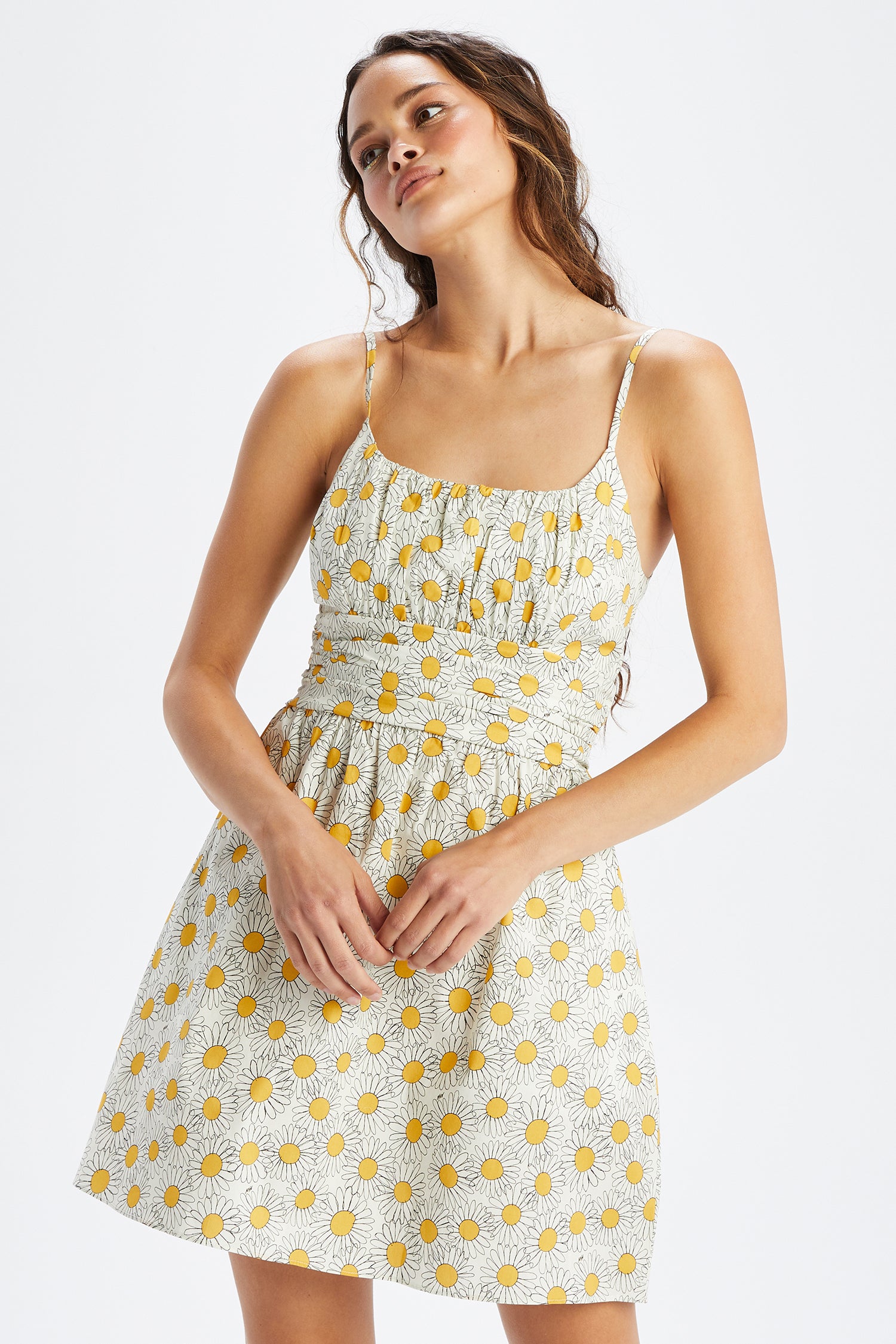 A model wears the Mini Lucy Strappy Cotton Ruched Dress