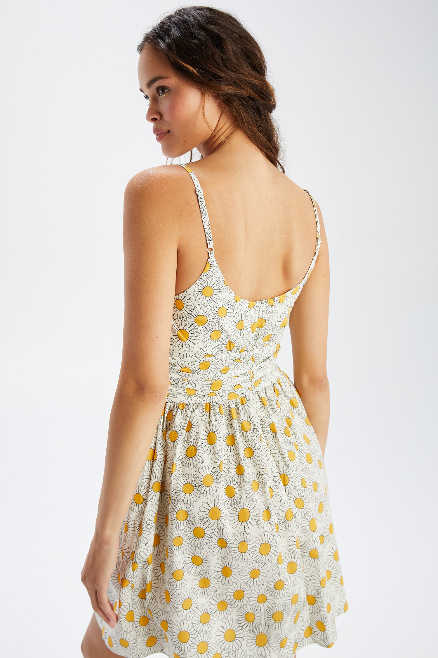 A model wears the Mini Lucy Strappy Cotton Ruched Dress