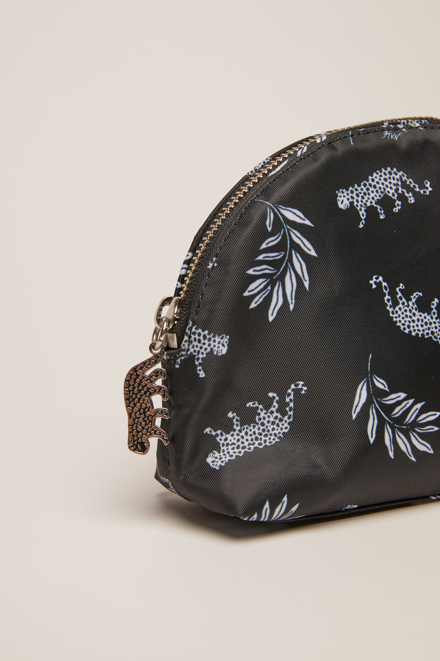 A leopard print cosmetic case with a leopard zip pull.