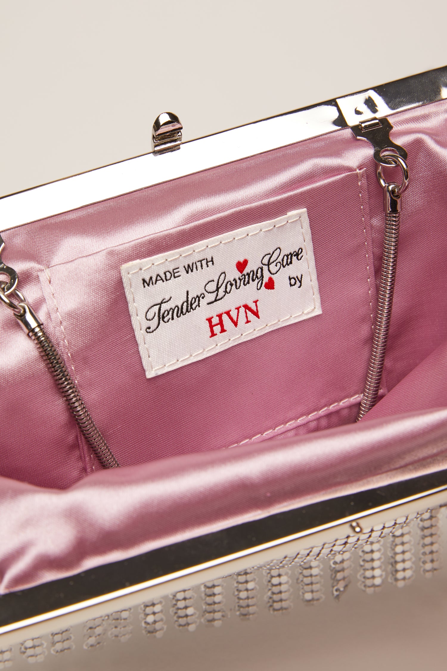 A small, silver chainmail bag with a silver chain handle. 