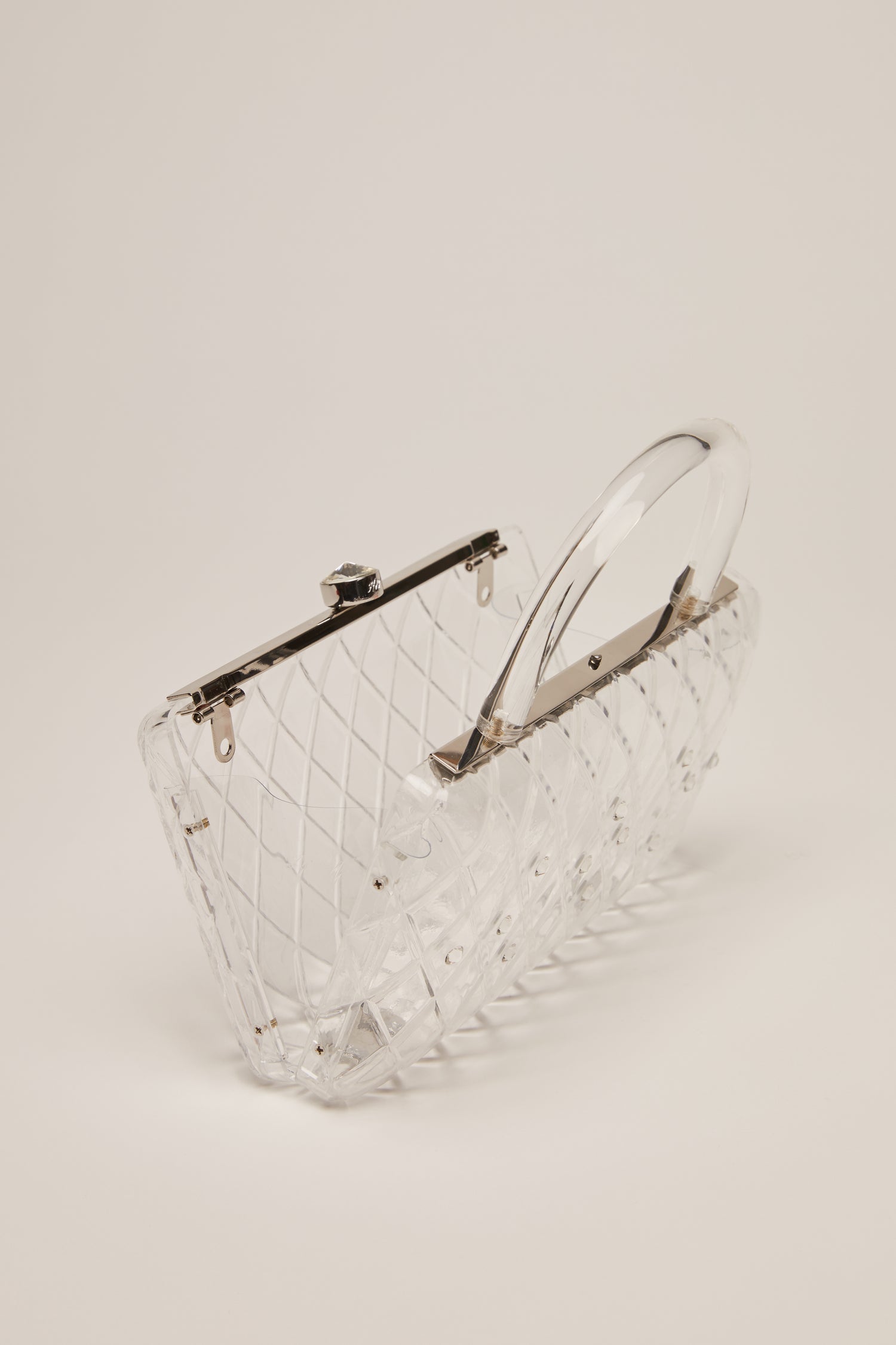 A clear acrylic handbag with crystals and a short handle. 